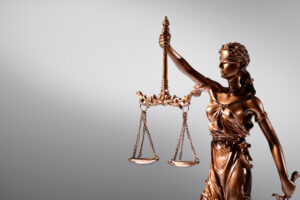 Imagem ilustrativa sobre contabilidade para escritório de advocacia mostrando uma estatueta do símbolo da justiça sobre um fundo cinza.