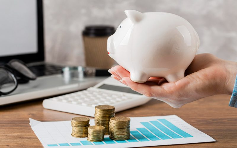 Imagem sobre recuperação financeira mostrando moedas e um cofre de porquinho de porcelana.