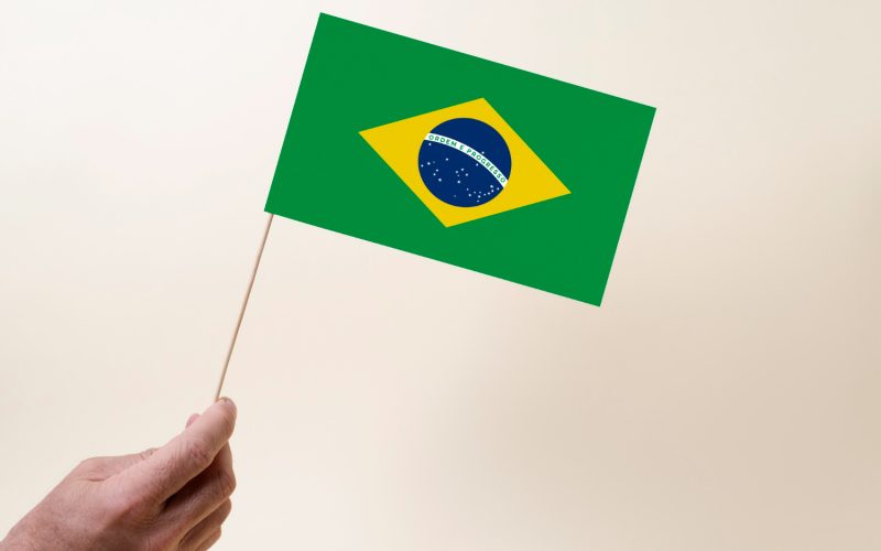 Imagem ilustrativa sobre o Simples Nacional 2024 mostrando uma pequena bandeira do Brasil sobre um fundo claro.